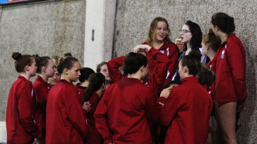 Seniors Grace Pope, Hannah Trimble, and Maddi Lyons get the team organized for cheers