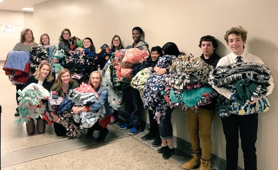 Cindy Widmar (far left) and members of the 2017 StuCo and IJag classes hold some of the blankets made for Covers of Comfort