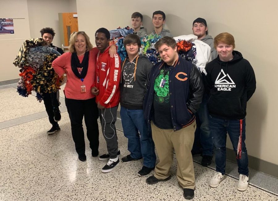 Cindy Widmar stands with some of the IJAG students who helped cut the material and tie the blankets

Front: DJ Hoskins (11), Cindy Widmar, DaShawn Tigges (11), Tristen Tison (11), and Chris Allen (11)

Back: Will McDonnell (11), Josh Weipert (11), Gage Boland (11), and Paul Breson (11)