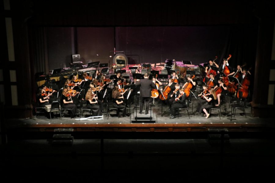 The orchestra, under the direction of Mr. Geyssens, performs at the Winter Concert